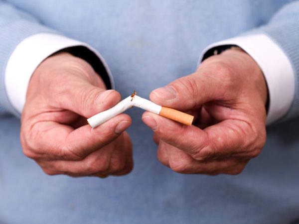 Rauchentwöhnung in Hamburg – Hendrik Neumann bricht eine Zigarette durch, Symbol für Hypnose und Softlaser beim Rauchstopp.