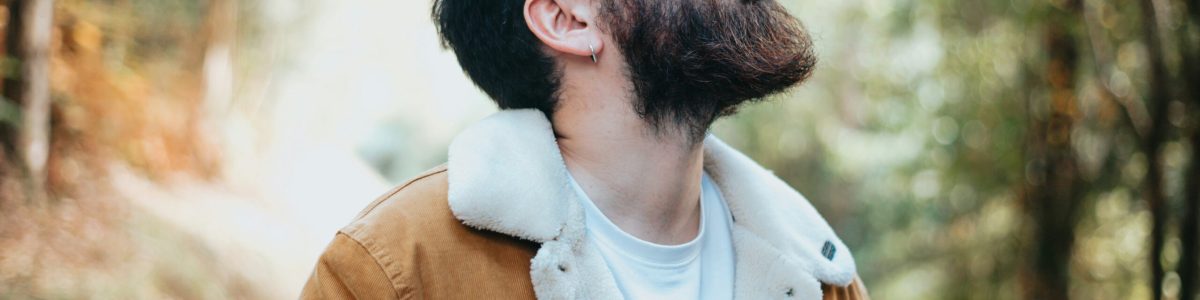 Mann mit geschlossenen Augen in einem ruhigen Wald als Symbol für bewusstes Innehalten bei Angst und Panikattacken